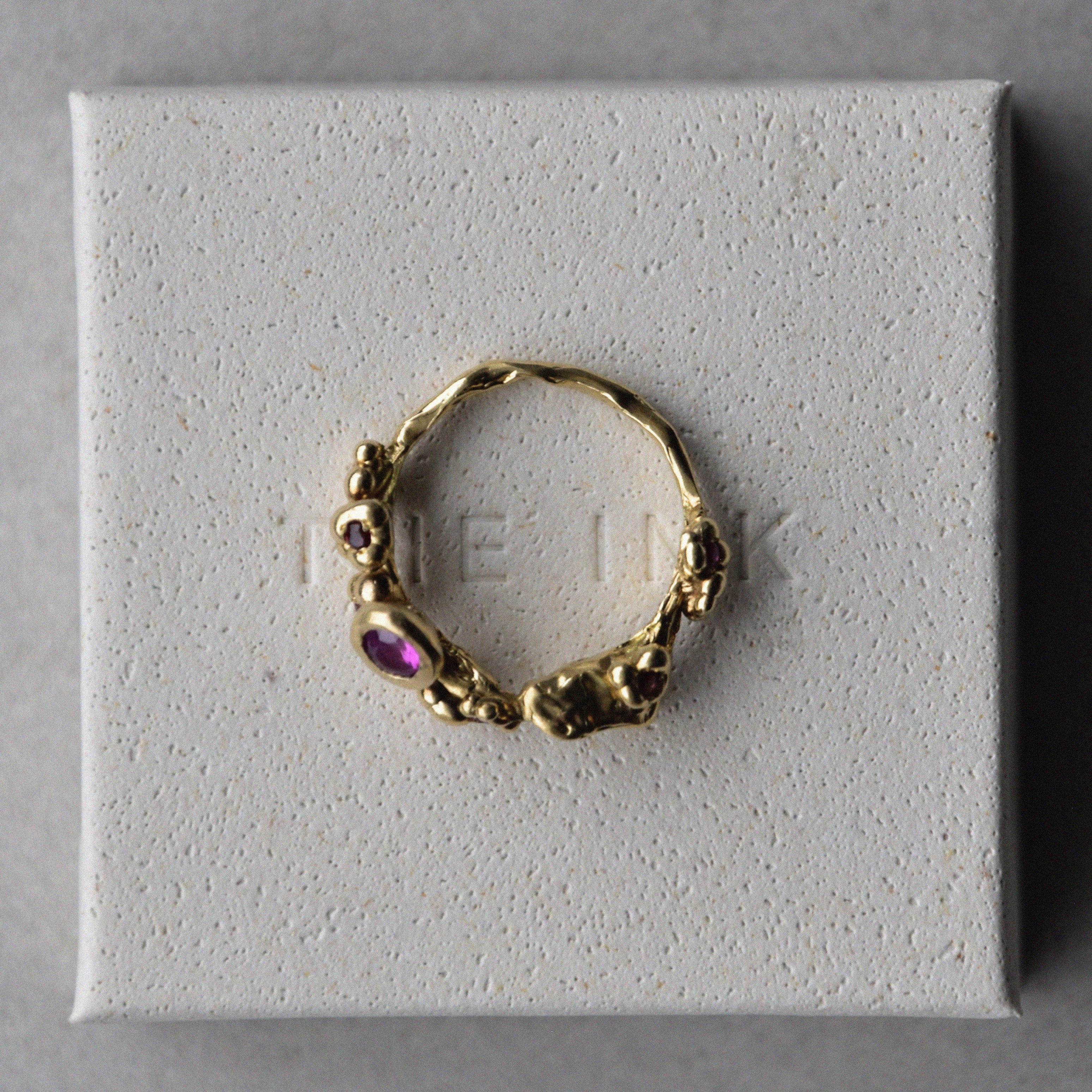 Anillo hecho a mano bañado en oro con incrustaciones sobre la caja reciclada de The Ink