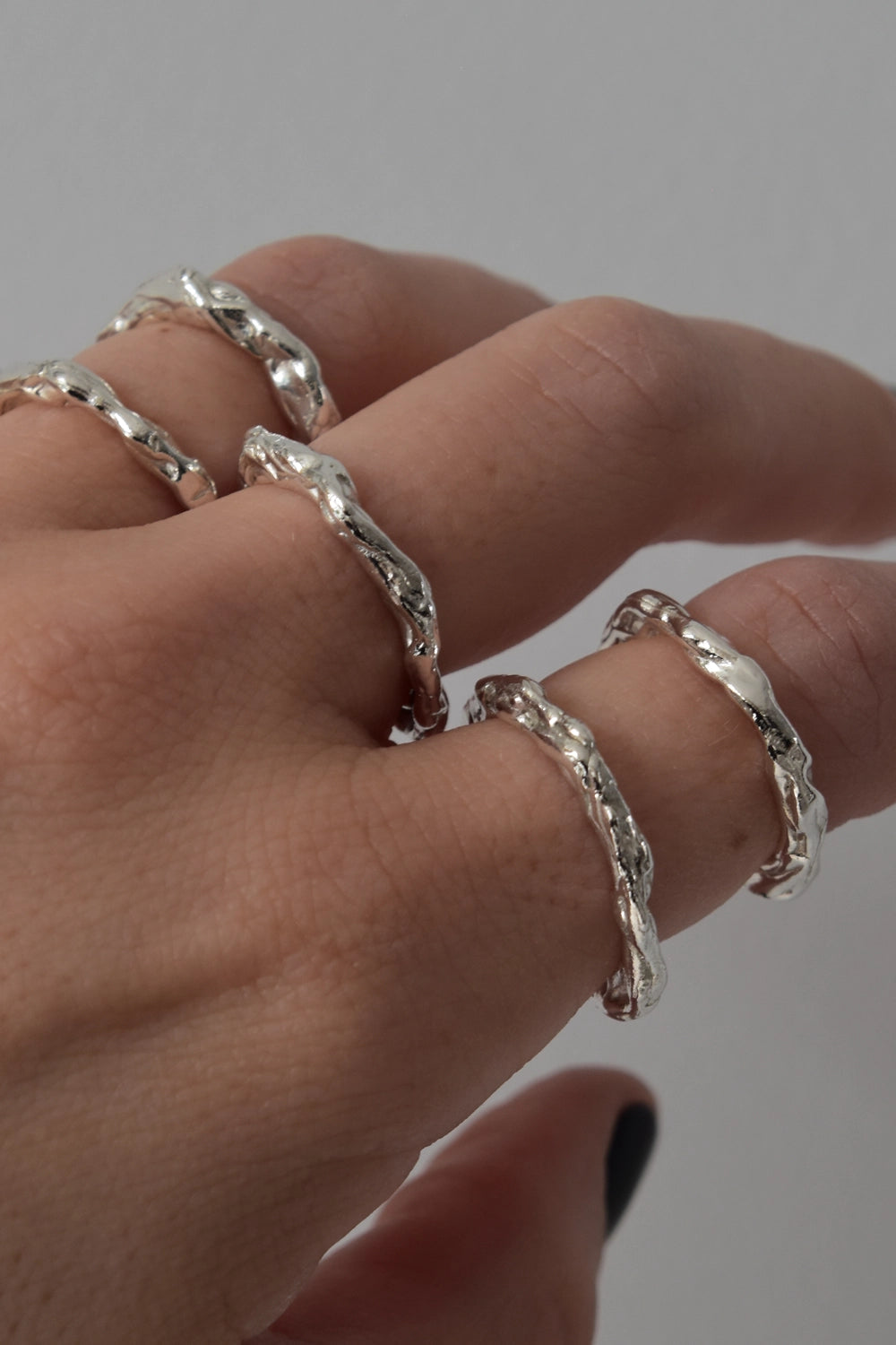 Mano con varios anillos Kopf hechos a mano en plata
