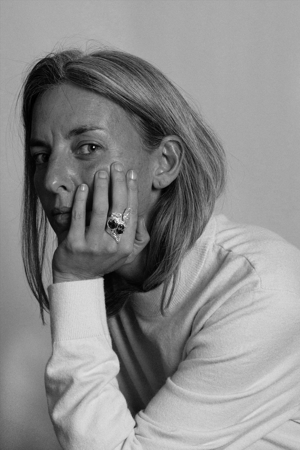 Foto en blanco y negro de una modelo mirando a cámara llevando un anillo Stone en plata hecho a mano por The Ink