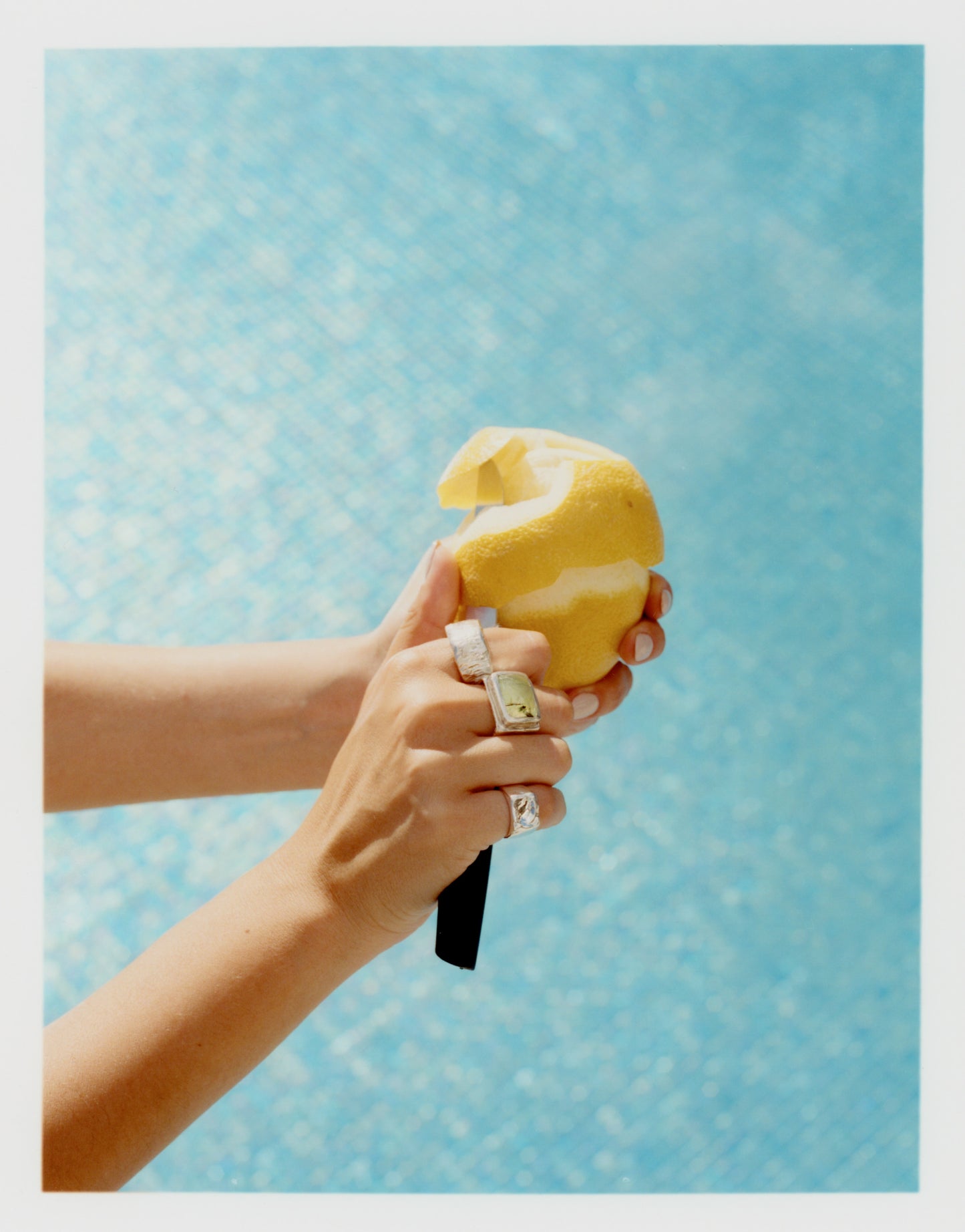 Manos femeninas cortando una fruta en la que se ven varios anillos únicos de The Ink